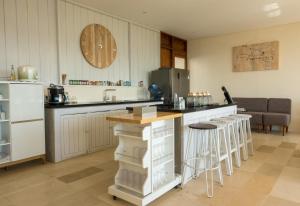 a kitchen with a counter and some stools in it at Villa Atas Pelangi in Kuta Lombok