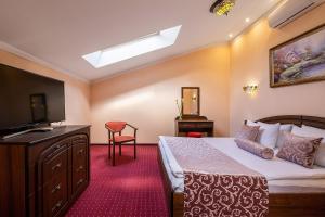 a bedroom with a bed and a flat screen tv at Edem Hotel Lviv in Lviv