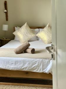 a bedroom with a bed with white sheets and pillows at Rosetta Fields Country Lodge in Henburg Park