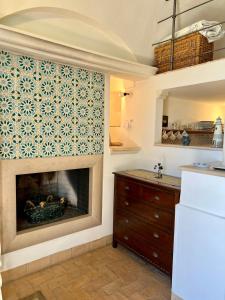 a kitchen with a fireplace in a room at Wine & Roses in Mattinata