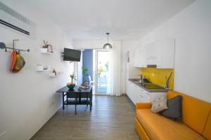 een keuken en een woonkamer met een bank en een tafel bij Fratino Pigro Residence in Alba Adriatica