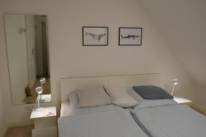1 dormitorio con 1 cama y 2 cuadros en la pared en Haus Sommerfrische, en Südstrand