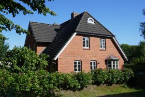 una casa de ladrillo rojo con techo negro en Haus Sommerfrische, en Südstrand