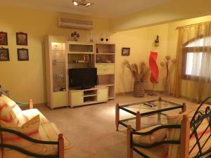 Villa Dina في شرم الشيخ: غرفة معيشة مع تلفزيون وطاولة زجاجية