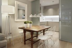 a kitchen with a wooden table and white chairs at Easo Suite 1 by FeelFree Rentals in San Sebastián