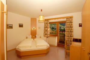 una camera con un grande letto e una finestra di Hotel Gurschler a San Leonardo in Passiria