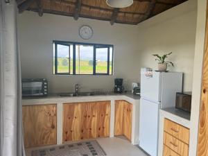 a kitchen with a white refrigerator and a window at Rosetta Fields Country Lodge in Henburg Park
