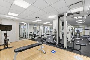 Midtown East 3BR w Doorman Gym nr Bloomingdales NYC-915 في نيويورك: صالة ألعاب رياضية مع أجهزةٍ جري وأجهزة في الغرفة