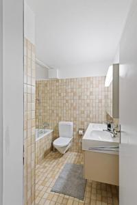 y baño con aseo, lavabo y bañera. en Beautiful Boutique Apartment DRAHTZUG14, en Zúrich