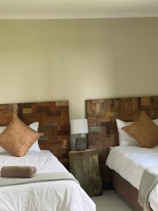 2 nebeneinander sitzende Betten in einem Schlafzimmer in der Unterkunft Rosetta Fields Country Lodge in Henburg Park
