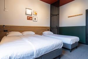 2 Betten in einem Hotelzimmer mit weißer Bettwäsche in der Unterkunft Weber Hotel in Amsterdam