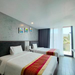 隆海的住宿－Oceanami Villa Long Hải - Vũng Tàu，酒店客房设有两张床和窗户。