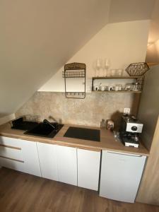 a kitchen with white cabinets and a sink at Apartman 7- Vila Stefanik in Trenčianska Teplá
