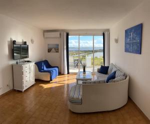 a living room with a couch and a television at Vista Mar Aldeia de Marim in Marim +4 photos