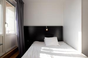 a bed in a room with a black headboard at Hotel Bishops Arms Mora in Mora