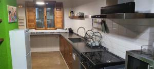 a kitchen with a sink and a stove top oven at Casa Rural Taíno in Benilloba