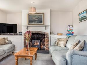 a living room with two couches and a fireplace at Pass the Keys Charming Cottage 1 Min Walk from Wareham Quay in Wareham
