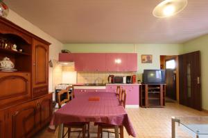 une cuisine avec des placards roses et une table avec des chaises dans l'établissement Chez frutos, à Vielleségure