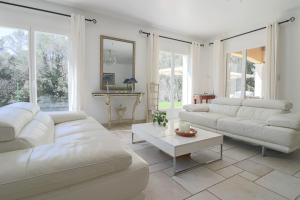 a white living room with white couches and a table at VILLA DES COLLINES - Absolute calm at 10' from the center in Antibes