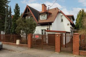 una casa blanca con una puerta y una valla en Quiet Bemowo House with Garden by Renters en Varsovia