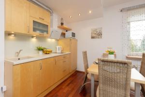 a kitchen with wooden cabinets and a table and a sink at Quiet Bemowo House with Garden by Renters in Warsaw