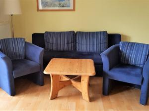 uma sala de estar com um sofá e duas cadeiras e uma mesa em Ferienwohnung Residenz am Buchenhain em Ostseebad Koserow