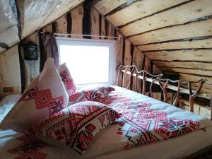 Schlafzimmer mit einem Bett mit roten und weißen Kissen in der Unterkunft Casa rustica in Braşov