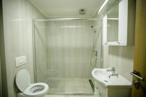 Un baño con ducha, inodoro y lavabo. en Kruzer centar, en Nikšić