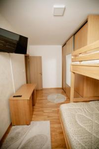 1 dormitorio con litera y escritorio con TV en Kruzer centar, en Nikšić 3 fotos más