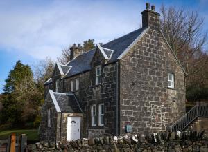 uma antiga casa de pedra com um telhado em Kilmory em Arisaig