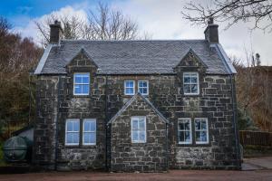 an old stone house with white windows at Kilmory in Arisaig +11 photos