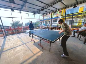 a man playing ping pong on a ping pong table at Live Free Hostel Rishikesh in Rishīkesh