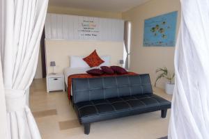 a bedroom with a bed with a black leather bench at Villa Atas Pelangi in Kuta Lombok