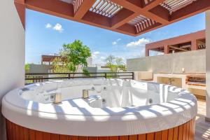 a large bath tub sitting on top of a balcony at Ciudad Mayakoba Homes by Vimex in Playa del Carmen +74 photos