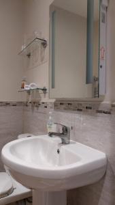 ein Badezimmer mit einem weißen Waschbecken und einem Spiegel in der Unterkunft Westwood Lodge B & B Boston in Boston
