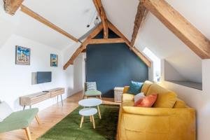 a living room with a yellow couch and a table at Cathédrale - Charmant appt pour 4 in Bayeux