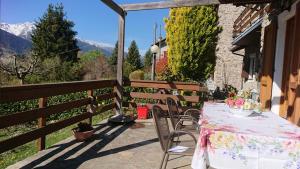 a table and chairs on a patio with mountains in the background at Casa delle Rose in Teglio