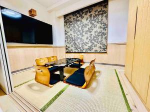 MoRi House IN 伊勢佐木町 في يوكوهاما: غرفة معيشة مع طاولة وكراسي صفراء