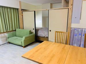 Zimmer mit einem Tisch, einem Stuhl und einem Bett in der Unterkunft MoRi House IN 伊勢佐木町 in Yokohama