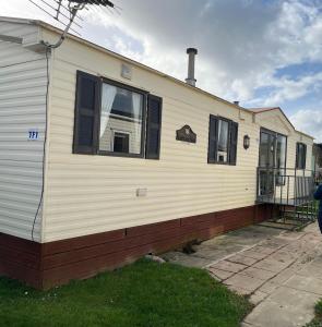 a mobile home with a porch and two windows at Cosy country style static holiday home in Aberystwyth