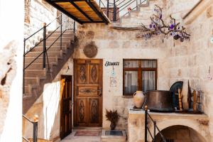 a stone building with a wooden door and stairs at Bayar Cave Suites in Urgup