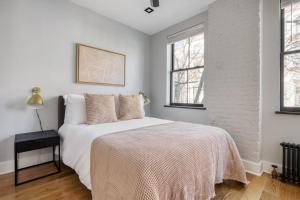 a white bedroom with a bed and two windows at West Village 3br w wd nr Pier 46 NYC-1098 in New York
