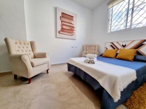 セビリアにあるDeluxe Apartment LA PLATAのベッドルーム1室(ベッド1台、椅子付)