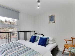 a bedroom with a bed with blue pillows and a window at Pass the Keys Cosy Cottage Hawkhurst in Cranbrook