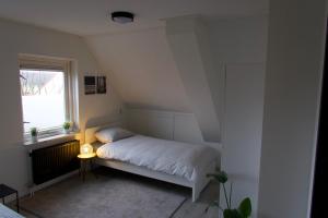 a small bedroom with a bed and a window at Luxurious Family Villa with swimmingpool big garden and jacuzzi in Zeewolde