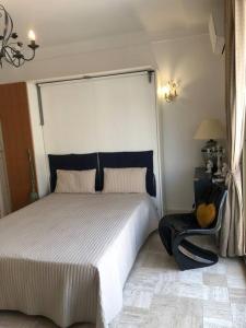 - une chambre avec un grand lit et une chaise dans l'établissement Croisette immo Beau studio sur la Croisette, à Cannes