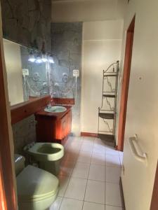 ein Badezimmer mit grünem WC und Waschbecken in der Unterkunft Casa Mora B&B in Cartago