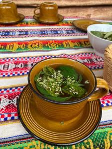 eine Schüssel Suppe auf einem Teller auf einem Tisch in der Unterkunft Casa familiar comunidad nativa ccaccaccollo in Cusco