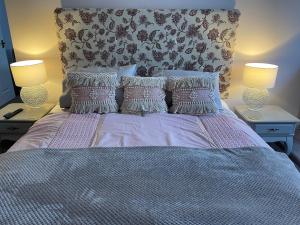 a bedroom with a bed with pillows and two lamps at The Penrallt Country House Hotel in Aberporth