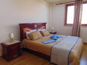 una camera da letto con un letto e un asciugamano blu di Ithaki Phinikoudes Apartments No. 106 a Larnaka